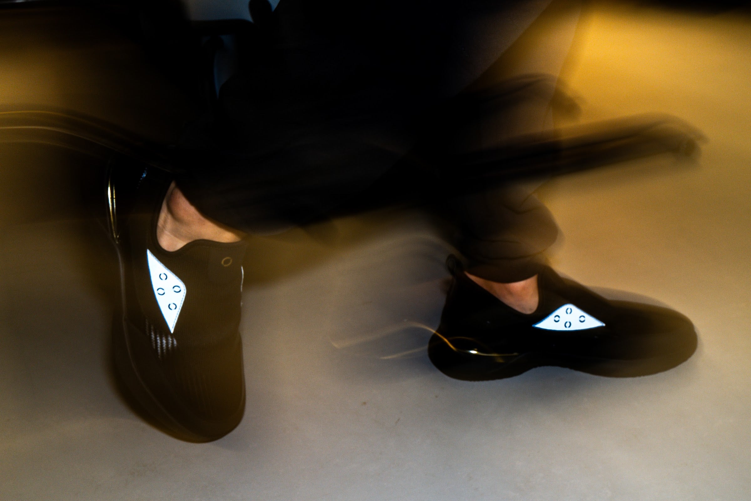 Motion-blurred shot of Snogs sneakers mid-stride on a hospital floor